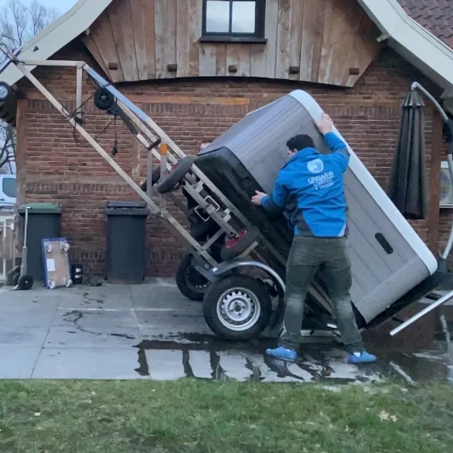 Monteur van Spaweb zet de spa op de transportkar