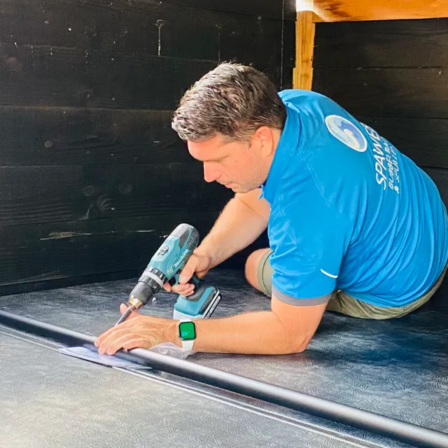 Monteur van Spaweb monteert een coverlift met een accuboormachine