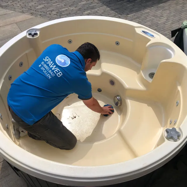 Monteur van Spaweb maakt een ronde spa schoon