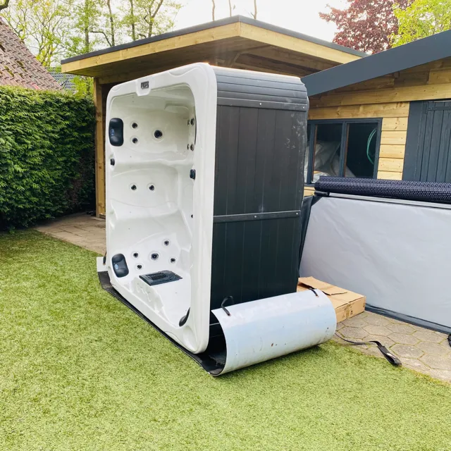 Spa op de zijkant met slidemat in een smalle tuindoorgang