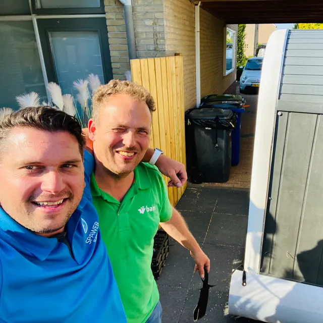 Selfie van een Spaweb-medewerker met een klant bij de levering
