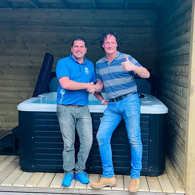Medewerker van Spaweb met een klant bij de geplaatste spa