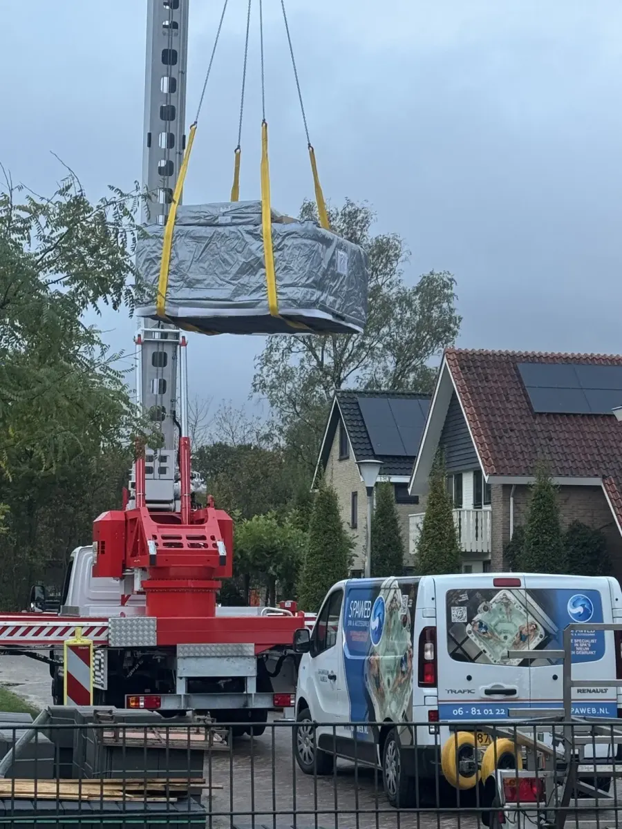 Spa wordt met een kraan uit een tuin getild